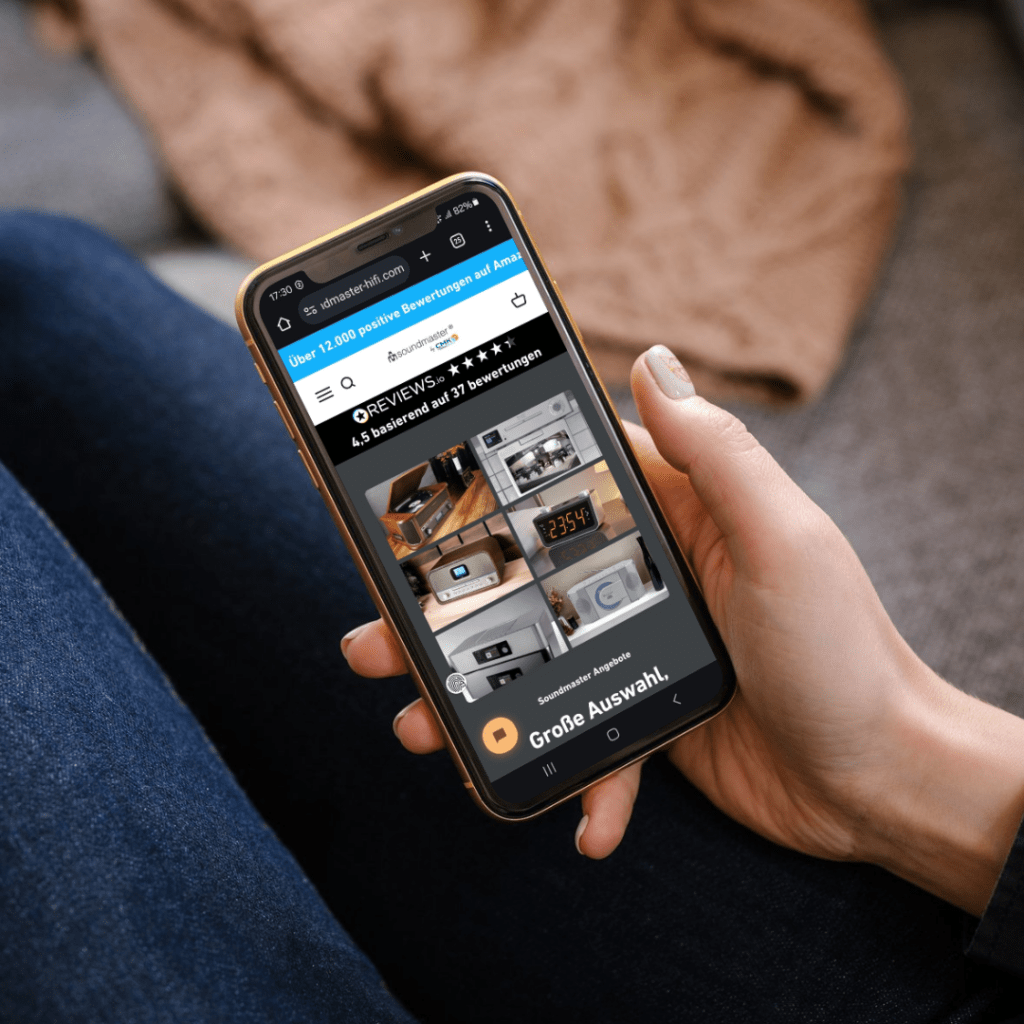 dame hält smarthphone in der hand, onlineshop von soundmaxx-online.de sichtbar, responsive auf smartphone